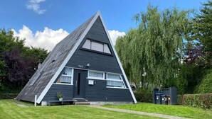 Un edificio moderno dalla forma triangolare, con esterno scuro, un piccolo portico e il numero '508' sulla facciata.