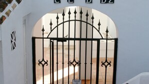 A white wall with a black metal gate and the letters "CLDDZ" above it. - Apartment Ocean Front - Rocas del Mar - Riviera del Sol. (Mijas Costa)