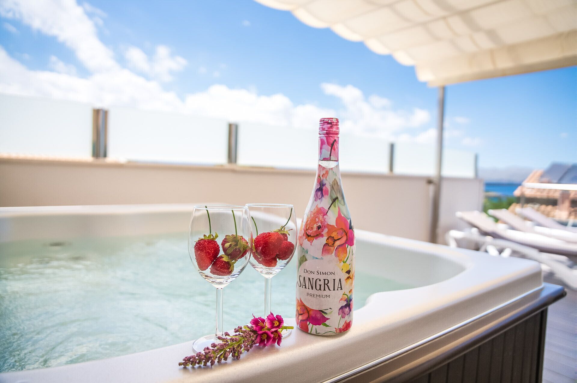 Un bain à remous avec deux verres de sangria et une bouteille de sangria premium de la marque Don Simon.
