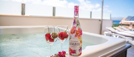 Un bain à remous avec deux verres de sangria et une bouteille de sangria premium de la marque Don Simon.