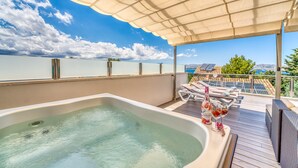 A rooftop terrace with a hot tub, lounge chairs, and a scenic view of the sea and mountains. - House near the sea Xiscama in Alcudia  (Alcúdia)