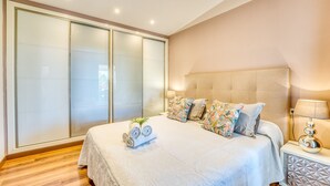 A bedroom with a large bed, a nightstand, a lamp, and a wardrobe. - House near the sea Xiscama in Alcudia  (Alcúdia)