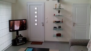 A living room with a television, a sofa, and a door. - HOUSE QUIET, COMFORTABLE, LUMINOUS (Cesson-Sévigné)