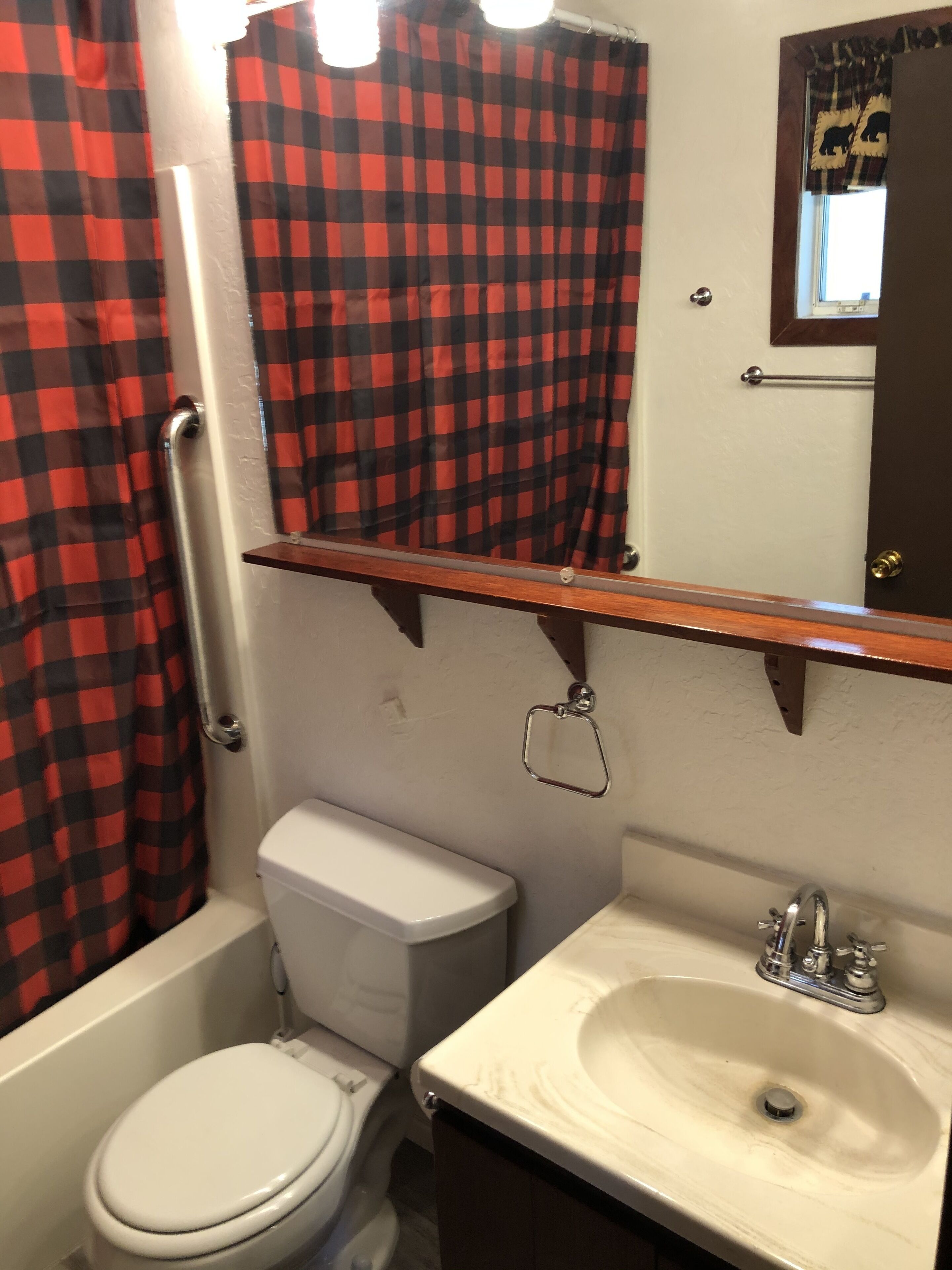 A bathroom with a white toilet, a sink, and a shower curtain.