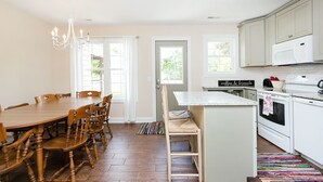 A kitchen with a dining table, chairs, a microwave, and a stove.