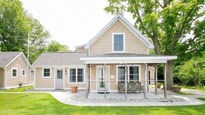 A two-story house with a covered porch, a front door, and a mailbox.