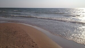 A beach with a sandy shore and gentle waves.