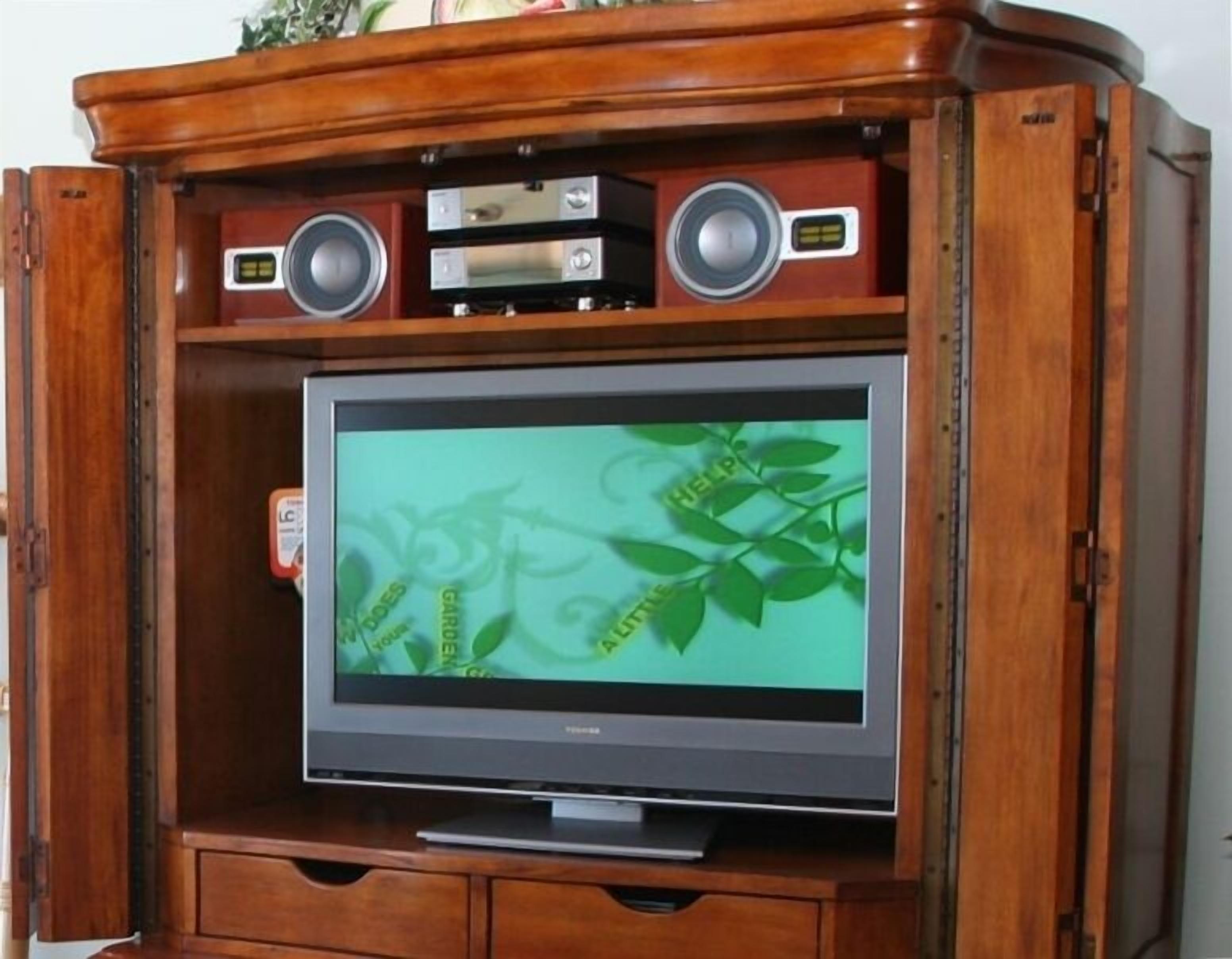 Een houten entertainmentkast met een flatscreen televisie, twee speakers en een dvd-speler.