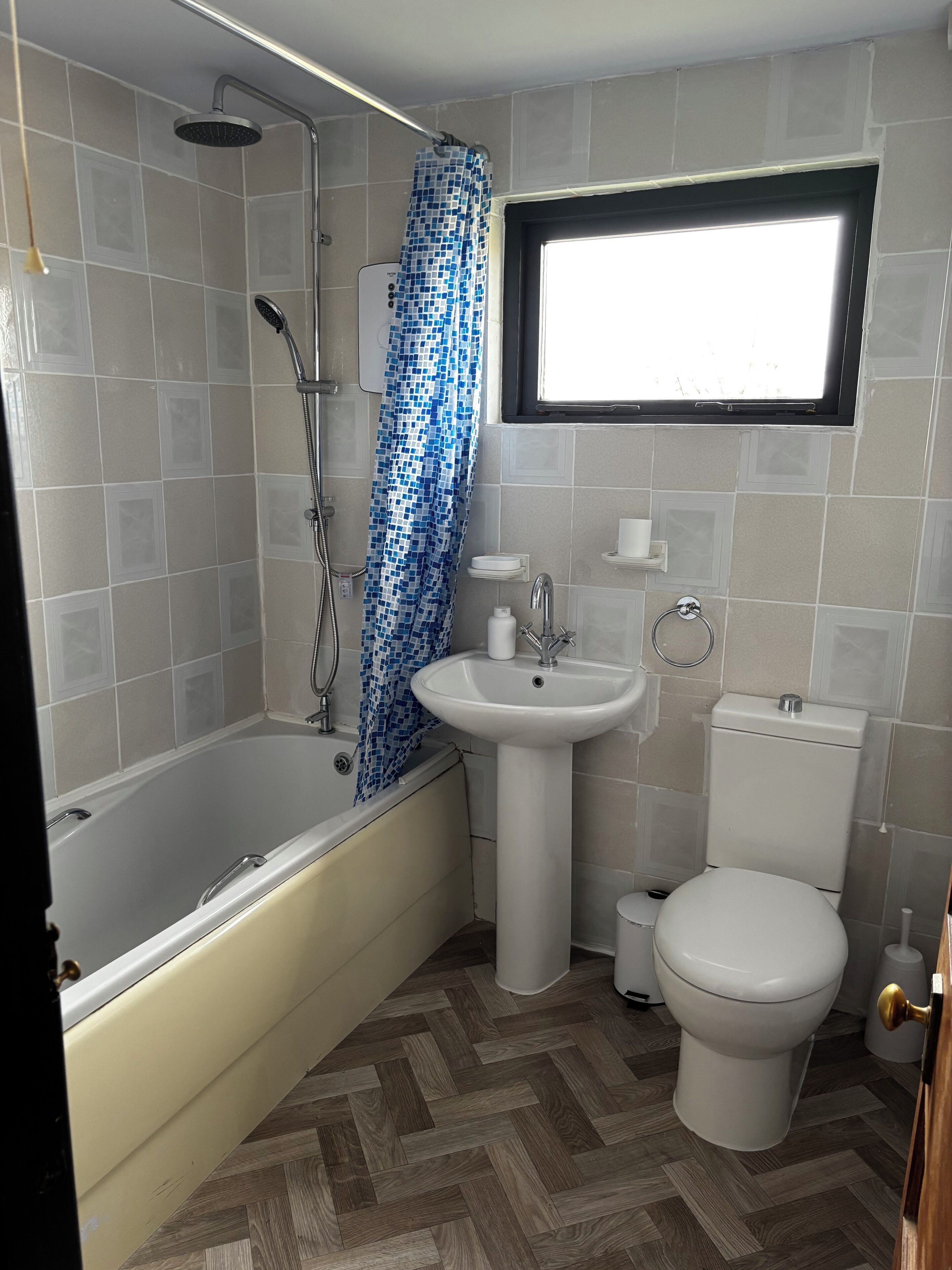A bathroom with a bathtub, a sink, a toilet, and a shower.