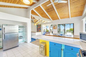 A modern kitchen with a large island, built-in appliances, and a view to a balcony.
