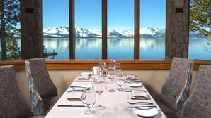 Mesa de comedor para seis personas con vista a la montaña a través de amplios ventanales.