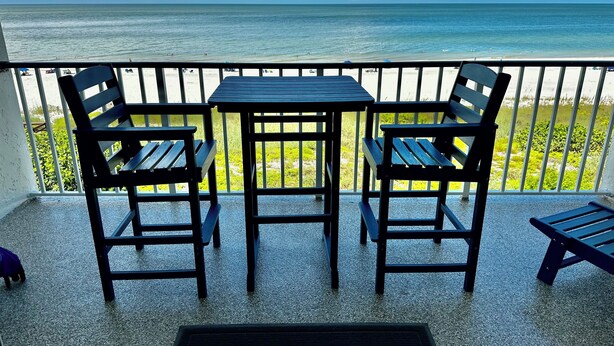 A balcony with a table and chairs overlooking a beach. - Newly remodeled beach front! SPECIAL RATE SEPTEMBER and OCTOBER (Marco Island)