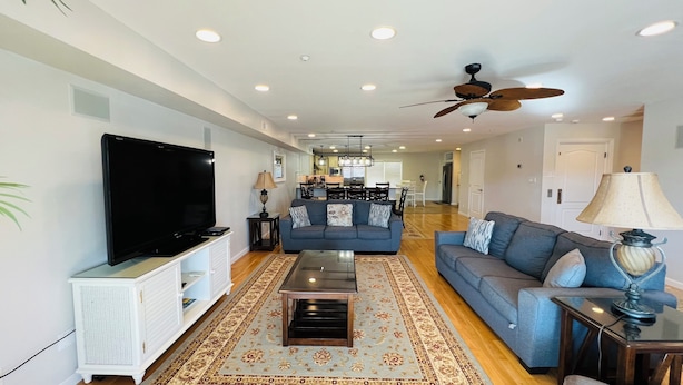 A spacious living room with a flat-screen TV, a sofa, a coffee table, and a ceiling fan. - BIG HOUSE WITH POOL OCEANVIEW 3 DECKS, 3 MASTER VERY NEAR OCEAN AND BOSRDWALK (Wildwood Crest)