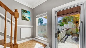A staircase with wooden balusters leading to a landing with a view of a patio area. - "Royal Palms Retreat" | Ocean Views | Dog-Friendly | Steps to the Beach | Community Pool (Panama City Beach)