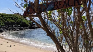 A beach sign with the text "SAND BEACH" attached to a tree. - MOLOKAI ISLAND   Two Bedroom Oceanfront Top End Unit!  (Kaunakakai)