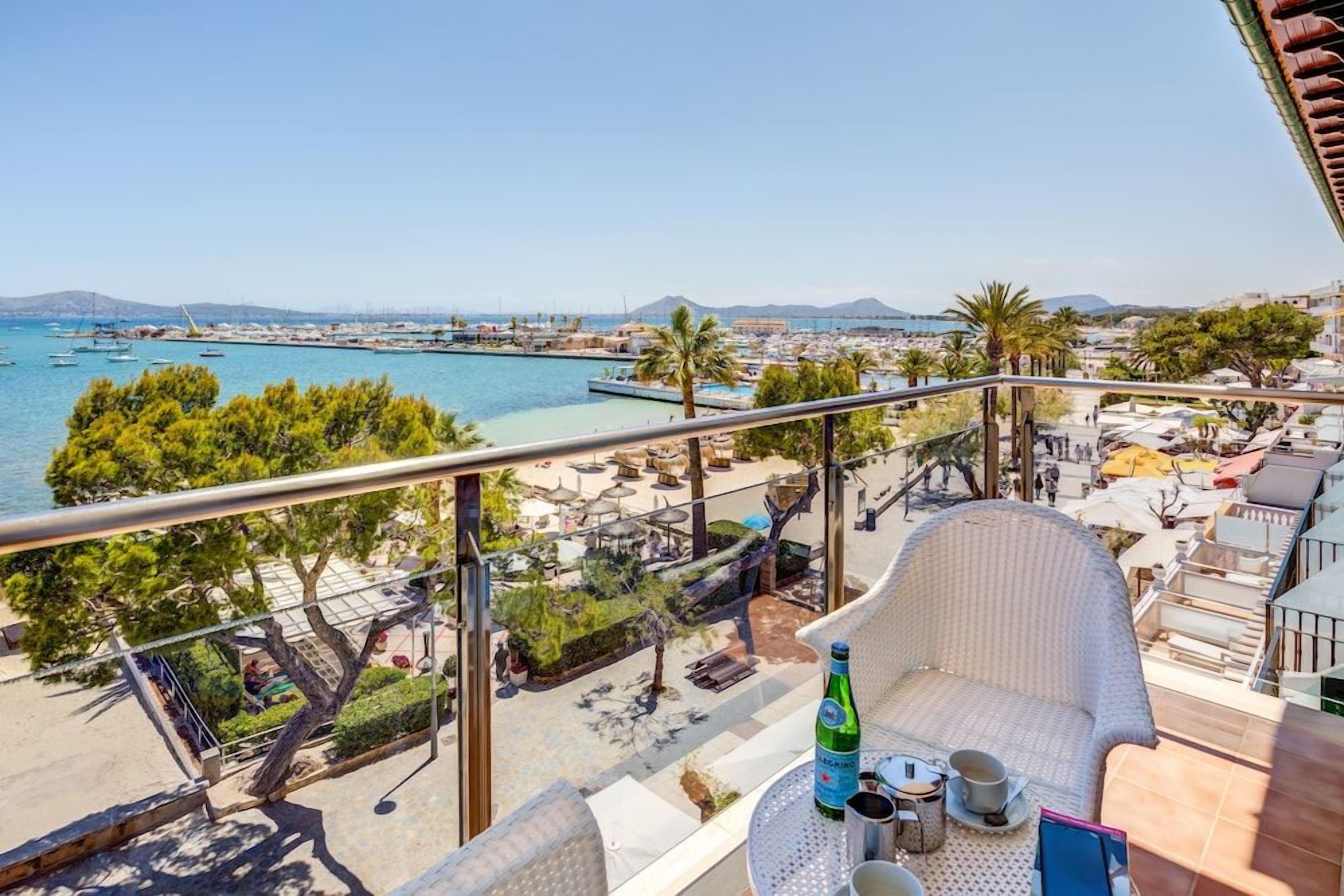 En balkon med udsigt over kysten, inklusive en strand og en lystbådehavn.