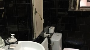 Un baño con lavamanos, inodoro y espejo blancos.