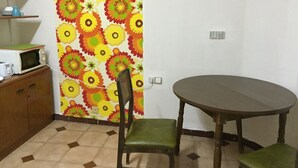 Una cocina pequeña con microondas, una mesa y una silla.