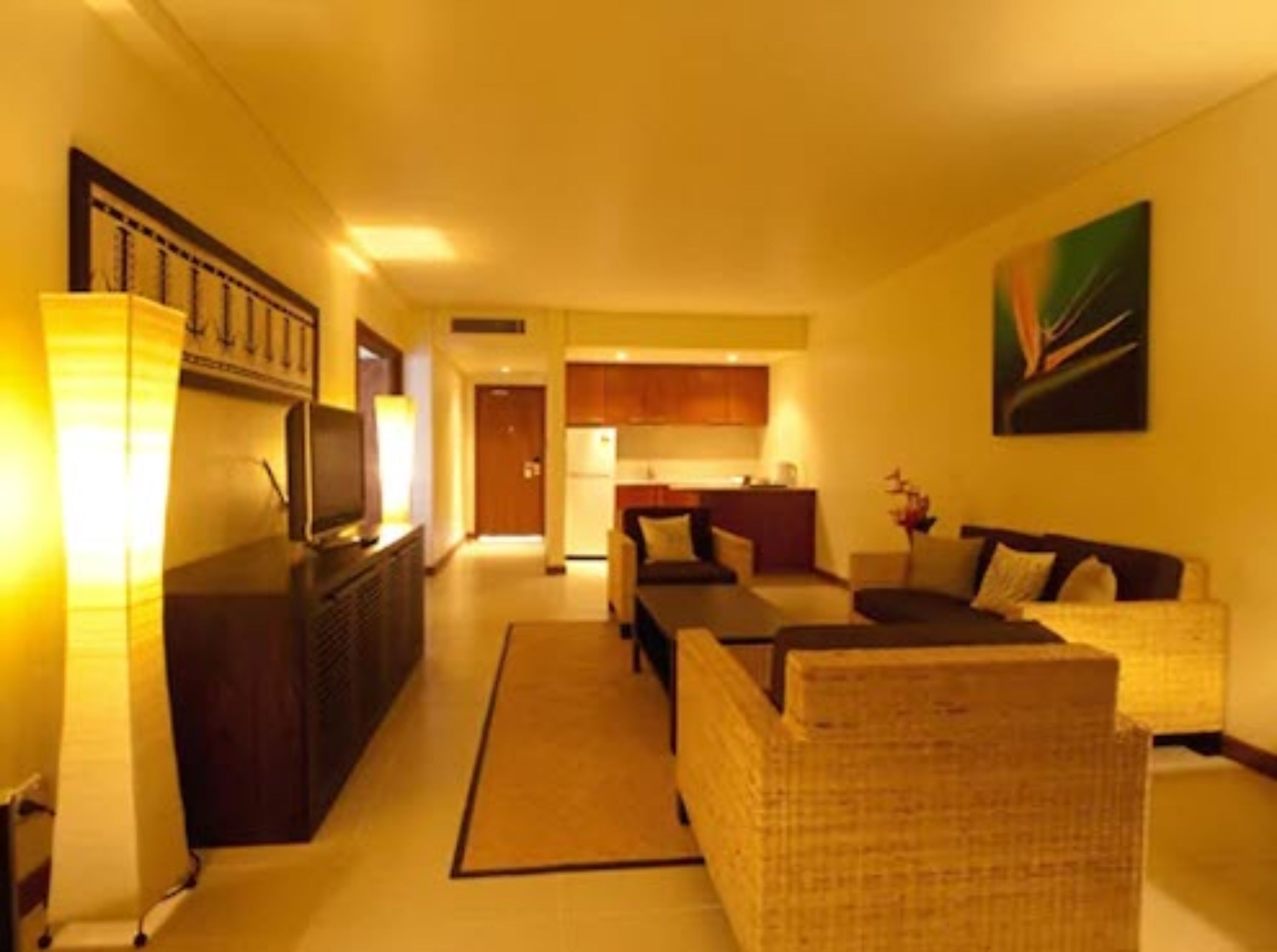 A hotel room with a living area, a kitchenette, and a dining area.
