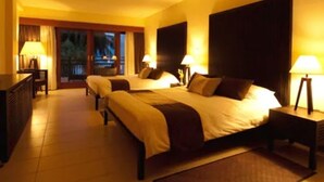 Habitación de hotel con dos camas, un escritorio y vistas al exterior.