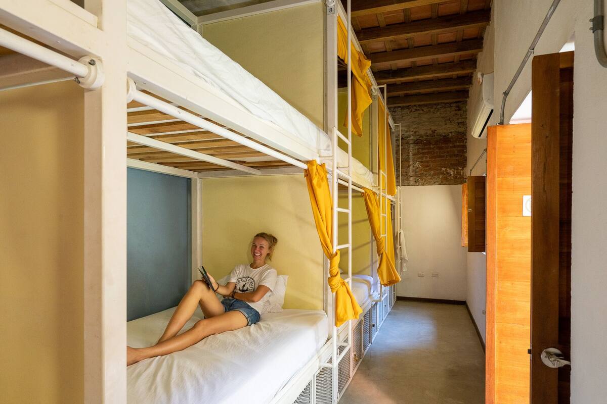 A bunk bed room with a person lying on the lower bunk.