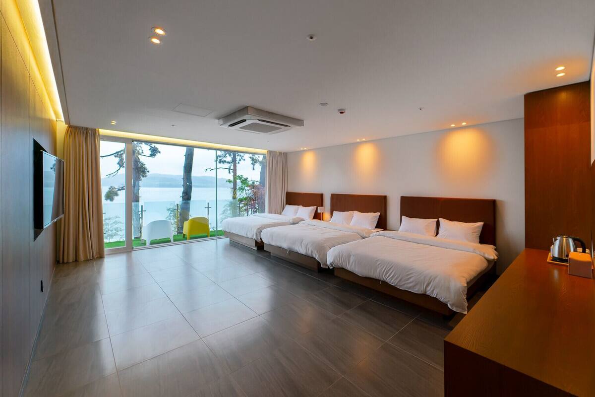 Ein modernes Hotelzimmer mit einem großen Bett, einem Fernseher und Meerblick.