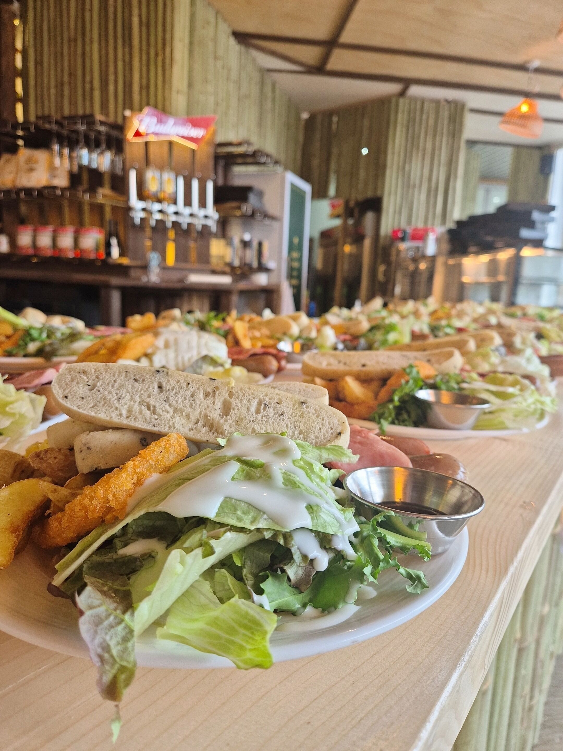 Un bufé con diversos platos, entre ellos sándwiches y ensaladas, en un restaurante.