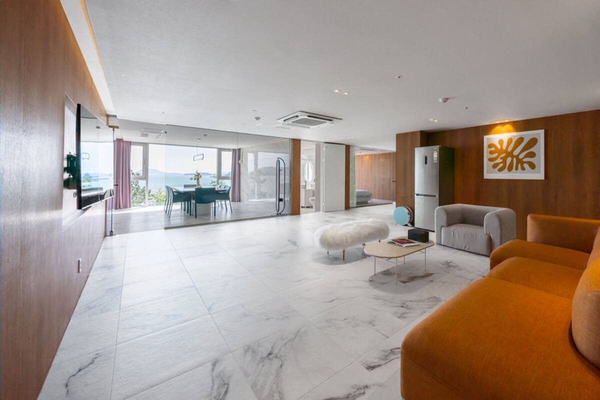 Ein großzügiger Wohnbereich mit modernem Design, ausgestattet mit einem großen Sofa, einem Couchtisch und einem Essbereich mit Blick.
