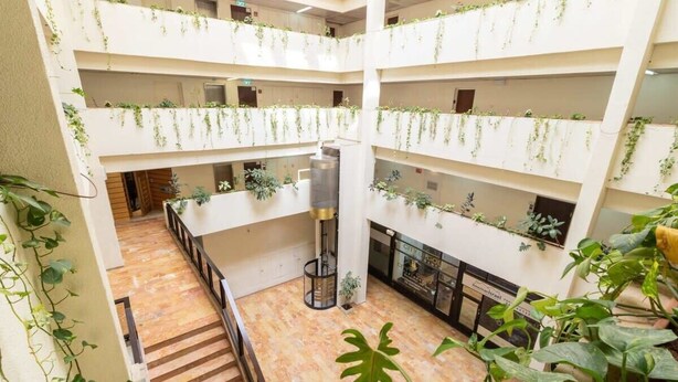A multi-level atrium with a central staircase, surrounded by balconies with greenery. - Studio between King David Hotel and Waldorf - Parking Included (Jerusalem)