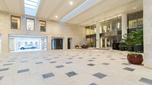 A spacious lobby with a high ceiling, large windows, and a tiled floor. - Haneviim Court: 1BR Apartment in Jerusalem (Jerusalem)