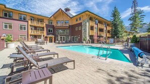 A hotel with a pool area, lounge chairs, and a mountain view. - Ski-in Ski-Out Great Views Extra Large Living Room Top Floor Two Balconies (Mammoth Lakes)