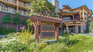 A multi-story lodge with a stone facade, wooden balconies, and a sign reading "Sunstone". - Ski-in Ski-Out Great Views Extra Large Living Room Top Floor Two Balconies (Mammoth Lakes)