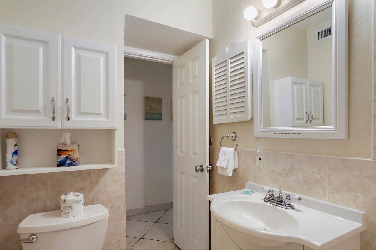 Un baño con inodoro, lavabo y armarios.