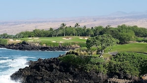 A coastal golf course with a view of the ocean and distant mountains. - Wai'ula'ula: You Can't Beat This View  (Waimea)