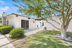 A modern building with a flat roof, a covered patio area, and a well-maintained lawn. - Happy Hour - Iconic Mid Mod Palm Springs (Palm Springs)