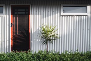 Stylish entrance with a palm plant and a small window above the door.