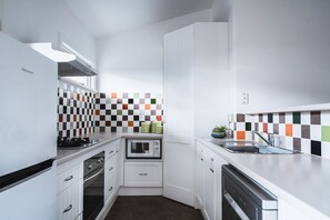 Kitchen with oven, microwave, and dishwasher, featuring a window above the sink.
