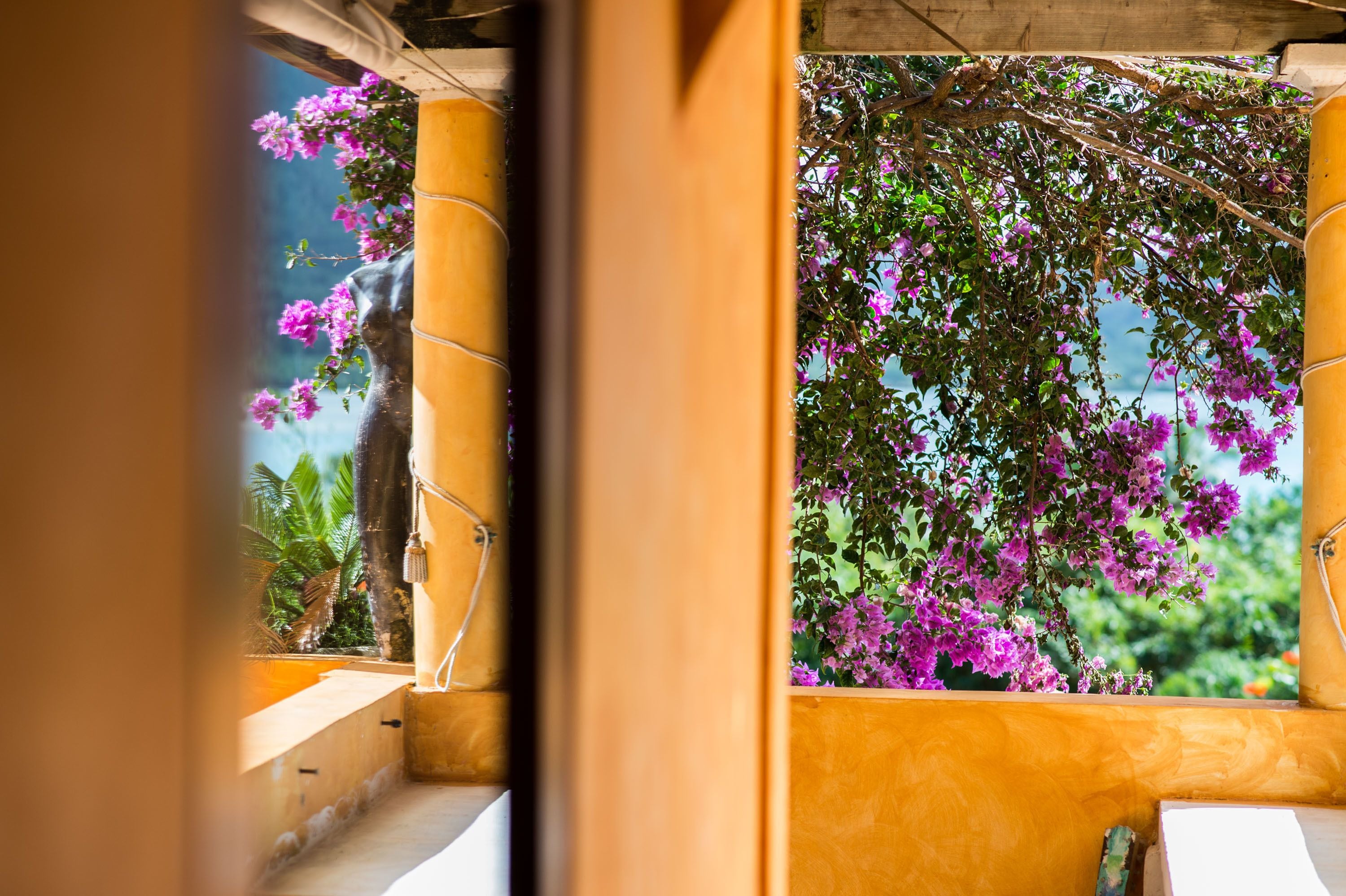 A view through a doorway with a yellow wall and a balcony.