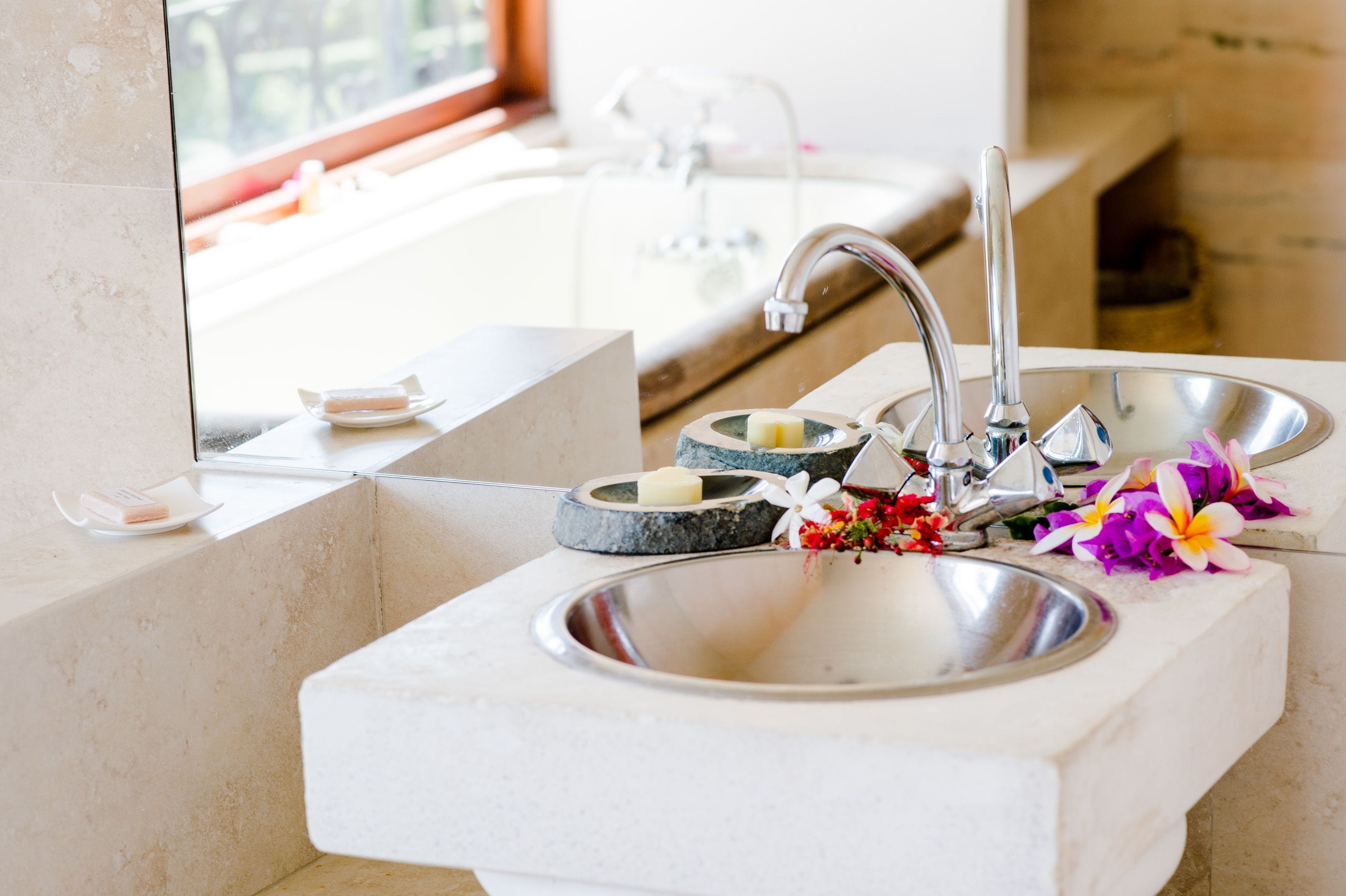 Une salle de bain avec deux lavabos, un miroir et une fenêtre.