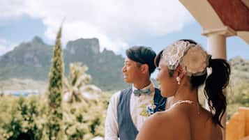 Una pareja en una boda con montañas al fondo.