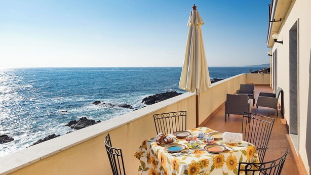 A balcony with a table set for two, overlooking the ocean. - Apartment with terrace with sea and Etna view (Stazzo)