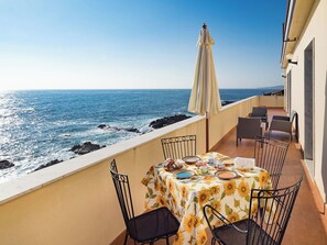 A balcony with a table set for two, overlooking the ocean. - Apartment with terrace with sea and Etna view (Stazzo)