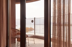 A balcony with a view of a body of water and mountains.