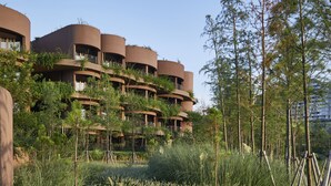 Un sendero que lleva a un edificio con varios balcones y un paisaje verde exuberante.