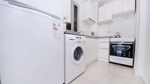 Eine Küche mit Waschmaschine, Mikrowelle und Backofen.