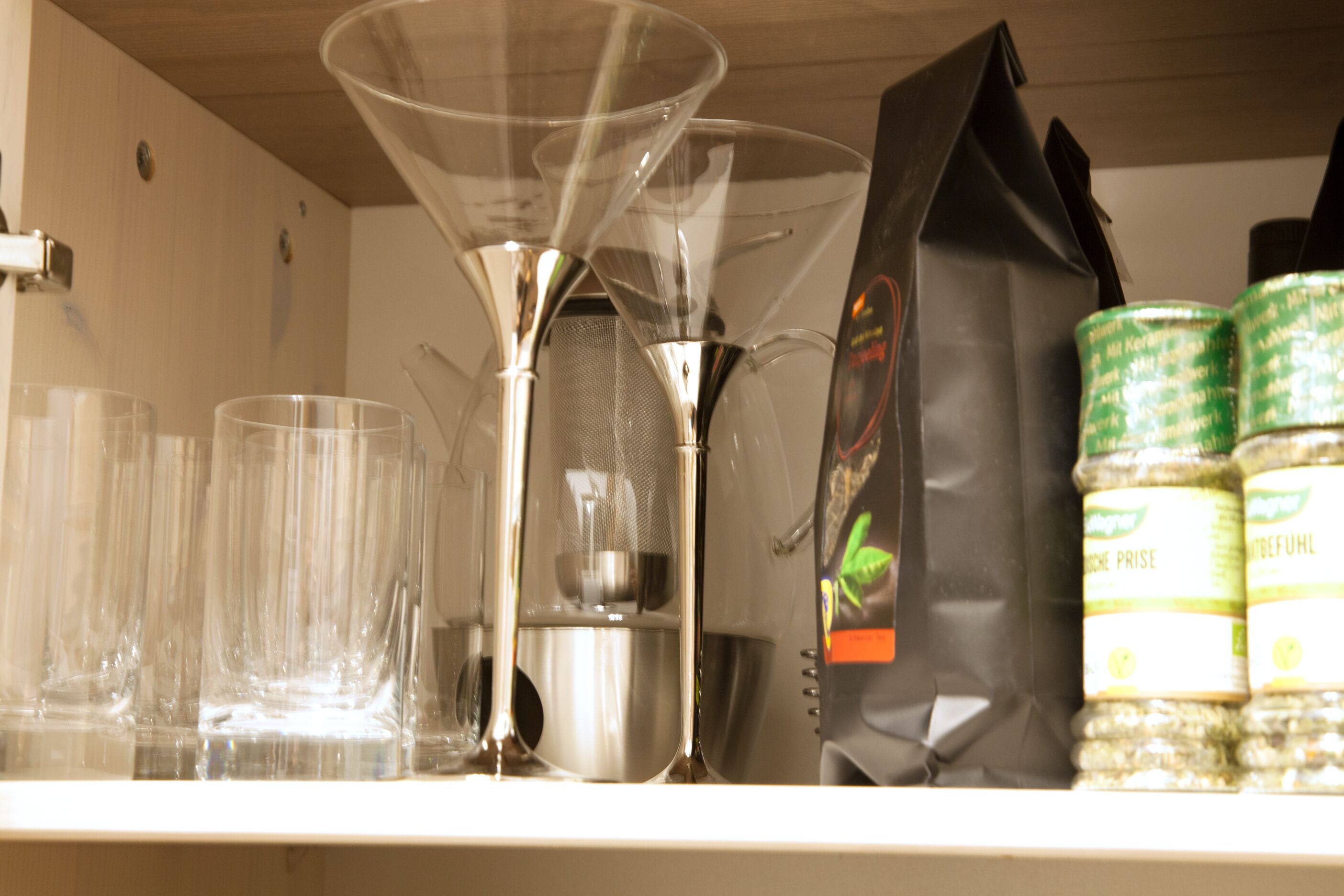 Una encimera de cocina con una cafetera, un hervidor y un paquete de granos de café.