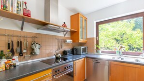 Una cocina con armarios de madera, estufa, microondas y lavabo.