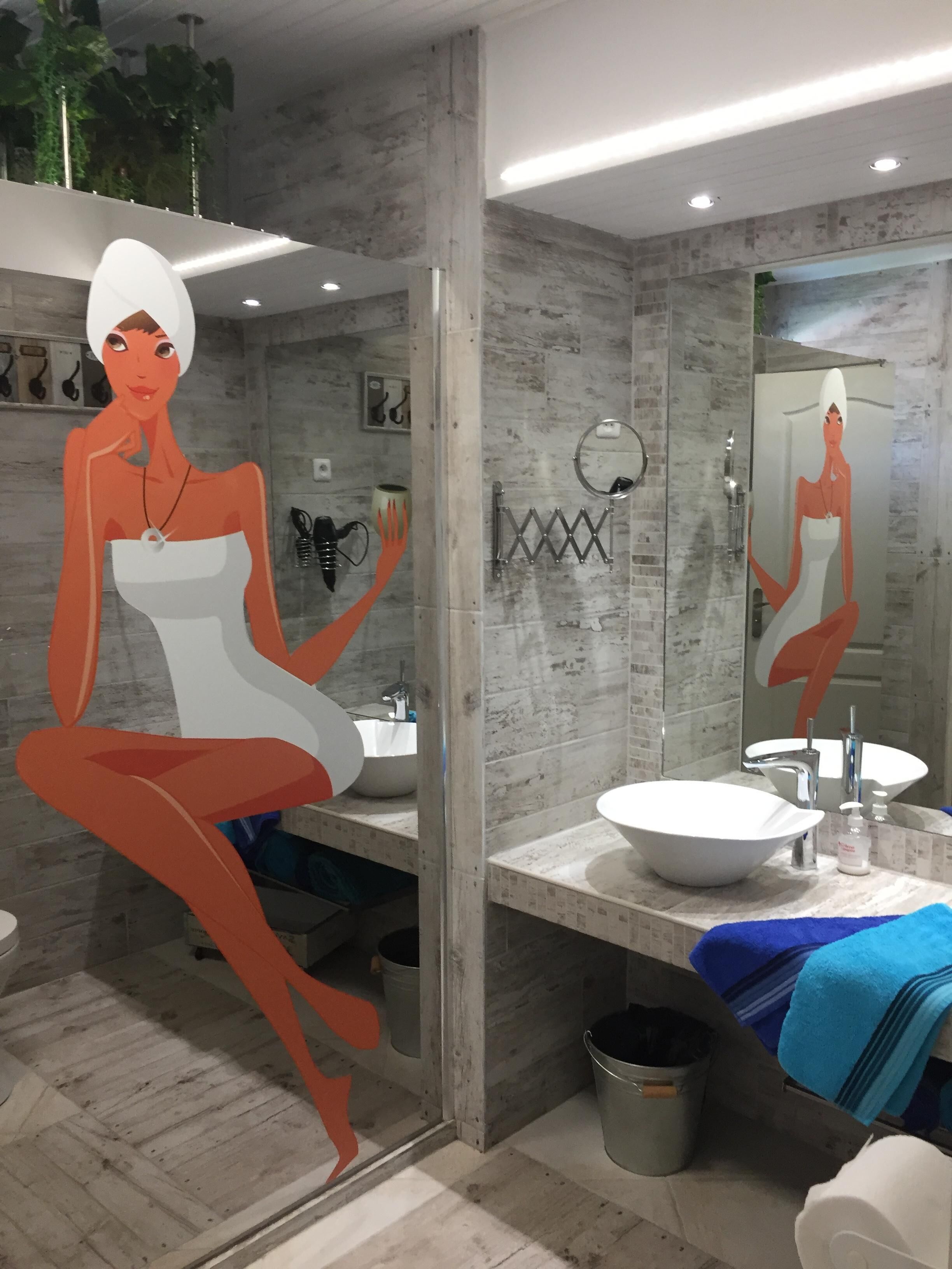 A modern bathroom with a large mirror, two sinks, and a towel rack.