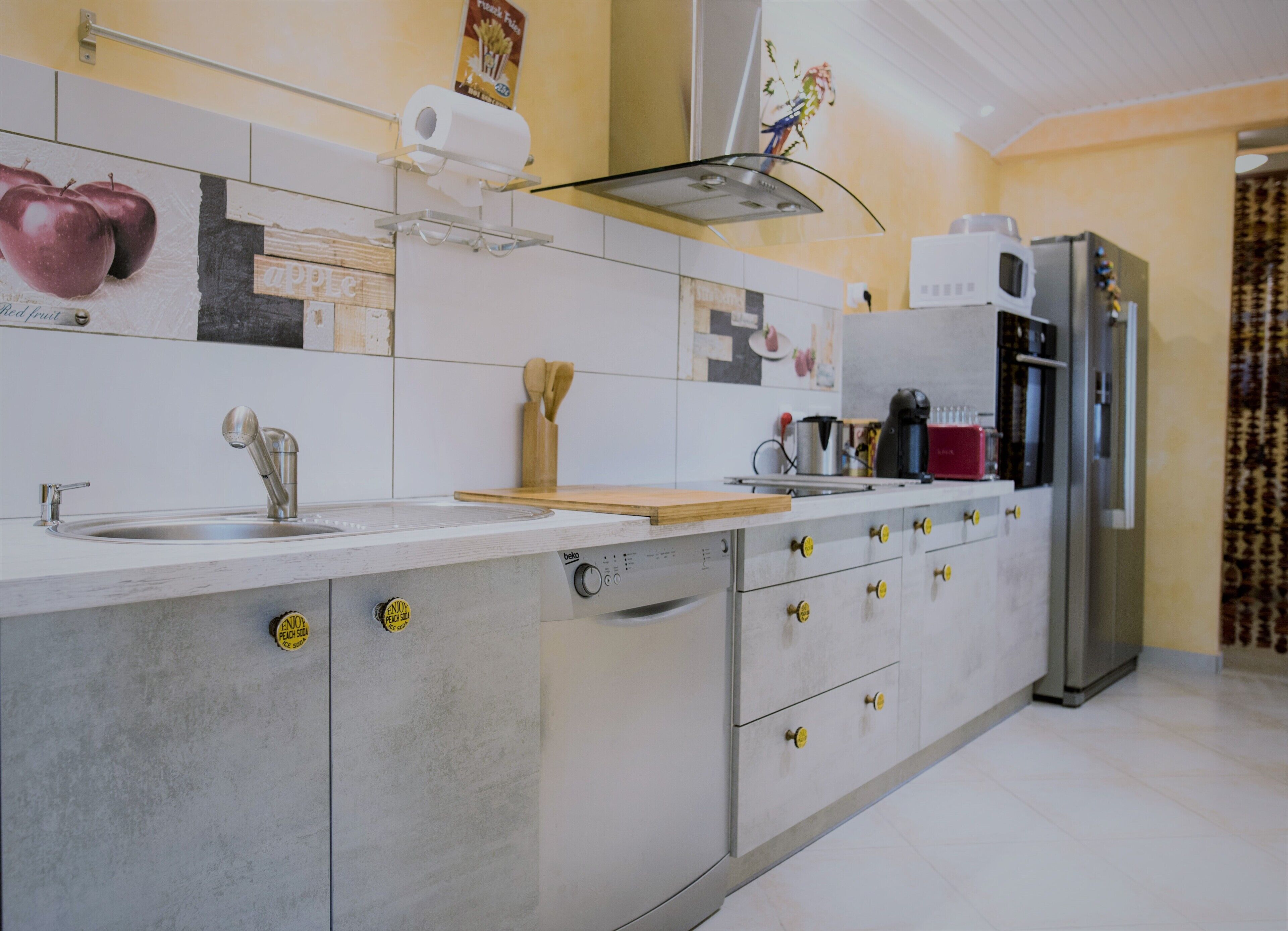 Una cocina moderna con un lavamanos de acero inoxidable, horno empotrado y refrigerador.