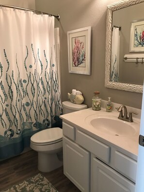 Une salle de bain avec des toilettes, un lavabo et un rideau de douche.